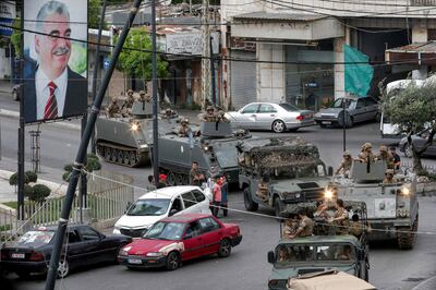 Lebanese army vehicles drive past a sign showing the portrait of late prime minister Rafik Hariri in the southern city of Sidon, in May. AFP