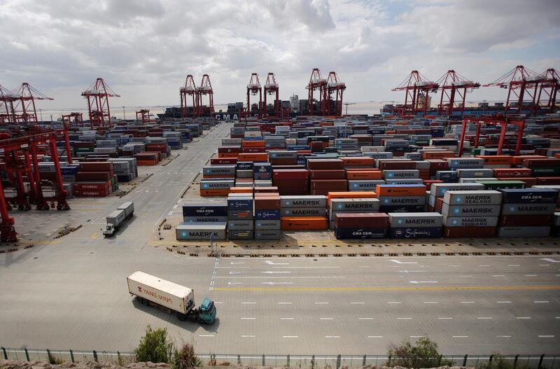 FILE PHOTO: Container trucks drive past the container area at the Yangshan Deep Water Port, part of the newly announced Shanghai Free Trade Zone, south of Shanghai September 26, 2013.   REUTERS/Carlos Barria/File Photo