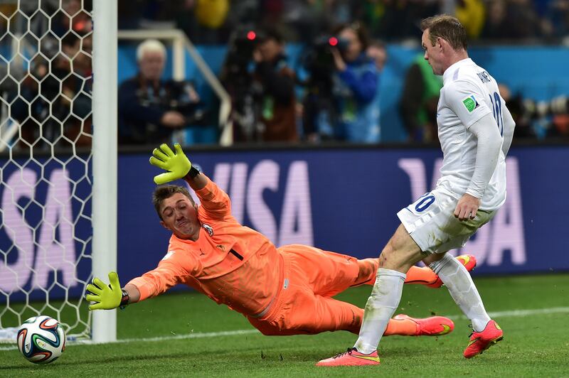 England's forward Wayne Rooney (R) scores past Uruguay's goalkeeper Fernando Muslera during the Group D football match between Uruguay and England at the Corinthians Arena in Sao Paulo on June 19, 2014, during the 2014 FIFA World Cup.  AFP PHOTO / NELSON ALMEIDA / AFP PHOTO / NELSON ALMEIDA