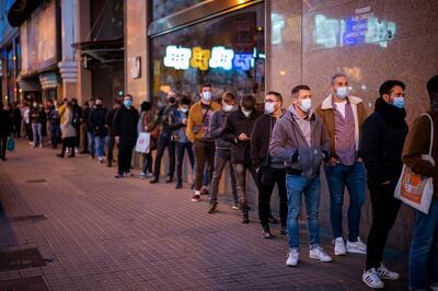 Volunteers line up as they wait to enter at a concert in Barcelona, Spain, Saturday, Dec. 12, 2020. Eager for a live music show after months of social distancing, more than 1,000 Barcelona residents gathered Saturday to participate in a medical study to evaluate the effectiveness of same-day coronavirus screening to safely hold cultural events. After passing an antigen screening, 500 of the volunteers were randomly selected to enjoy a free concert inside Barcelona's Apolo Theater. (AP Photo/Emilio Morenatti)