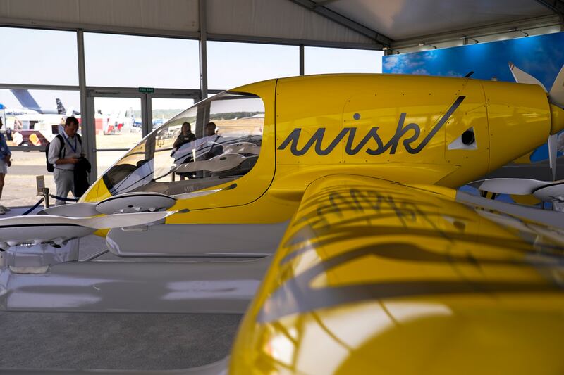 Visitors look at a model of the Wisk Aero autonomous aircraft. AP