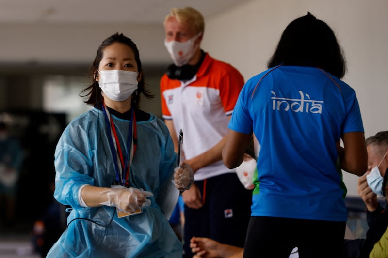 Members of the Netherlands and Indian Olympic teams wait for Covid-19 testing after arriving at Narita International Airport, serving Japan's capital Tokyo.