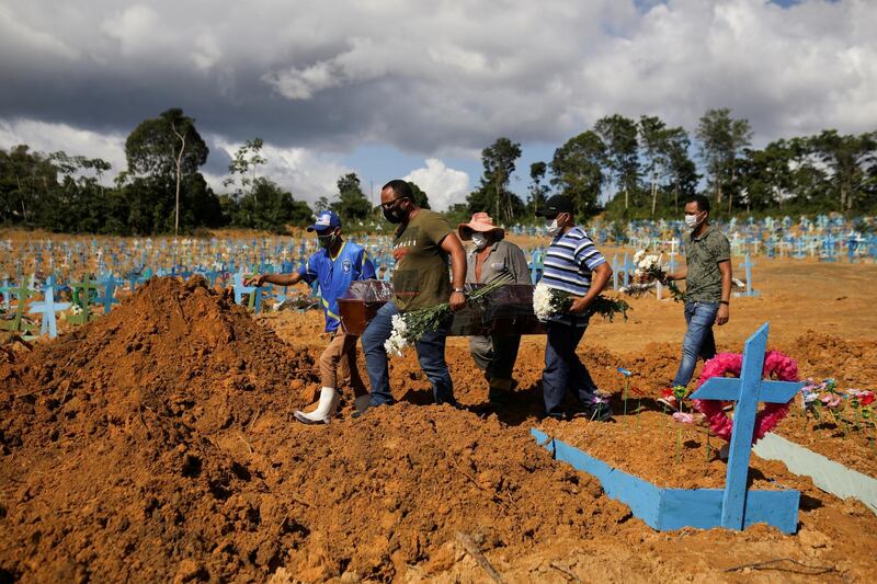 Sons of Veronica Ferreira, 73, who passed away due to the coronavirus disease (COVID-19), attend her burial at the Parque Taruma cemetery in Manaus, Brazil. Reuters