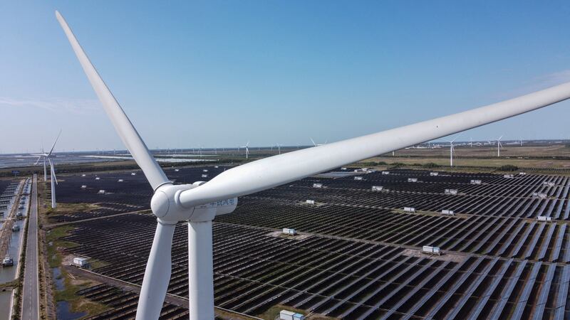 Solar panels and wind turbines work in an integrated power station in Yancheng city in Jiangsu province, China. AFP