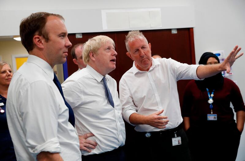 Britain's Prime Minister Boris Johnson (2nd L) and Britain's Health and Social Care Secretary Matt Hancock (L) speak with staff members during a visit to Pilgrim Hospital in Boston, eastern England, on August 5, 2019.  Prime Minister Boris Johnson promised new funding for Britain's state-run national health service (NHS) on Sunday, seeking to fulfil one of the promises of his 2016 Brexit campaign. Johnson pledged a one-off cash boost of £1.8 billion (2.0 billion euros, $2.2 billion) to immediately help frontline services, in a move that further fuelled speculation he is preparing for a snap election. During the referendum on Britain's European Union membership, Johnson's "Vote Leave" campaign promised to divert £350 million a week sent to Brussels to the NHS after Brexit.
 / AFP / POOL / Darren Staples
