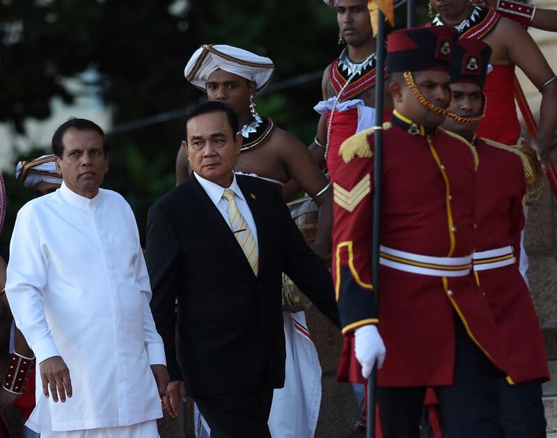 Thai Prime Minister Prayut Chan-O-Cha (C) walks with Sri Lankan President Maithripala Sirisena (L) during a welcoming ceremony at the Presidential Secretariat in Colombo on July 12, 2018.  Prime Minister Prayut Chan-O-Cha is on an official visit to Sri Lanka until July 13. / AFP / Ishara S. KODIKARA
