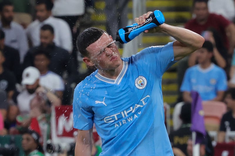 Manchester City's English midfielder Phil Foden splashes water on his face. AFP