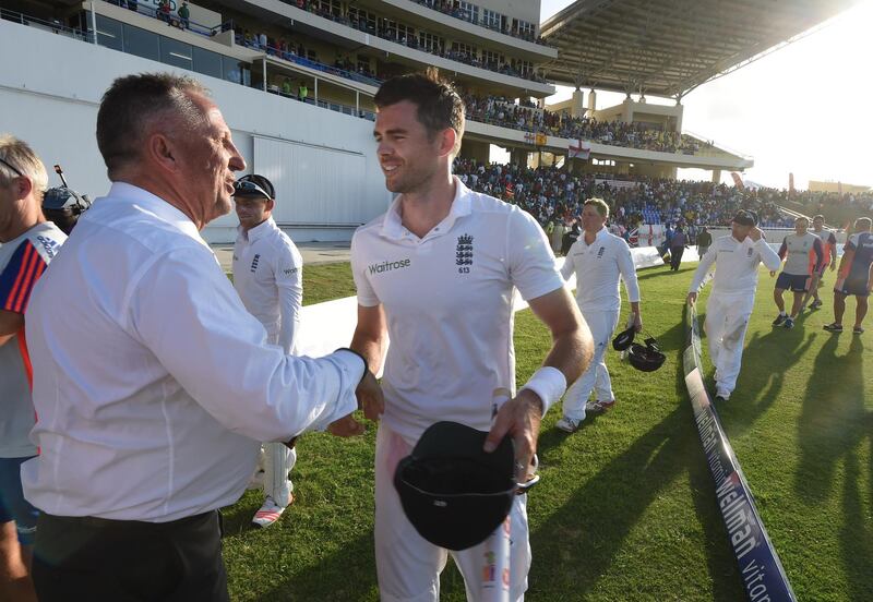 English fast bowler James Anderson (C) talks with former record holder Ian Botham (L) after Anderson became the highest ever English wicket taker with 384 after taking the wicket of West Indies captain Denesh Ramdin on day five of the first cricket Test match between West Indies and England at the Sir Vivian Richards Stadium in St John's, Antigua on April 17, 2015.  Anderson has taken the record from previous holder Ian Botham on 383.         AFP PHOTO/ MARK RALSTON (Photo by MARK RALSTON / AFP)