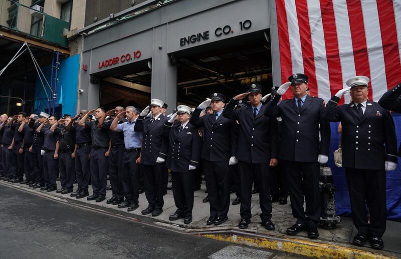 New York City Fire Department members stand outside Engine 10 and Ladder 10 firehouse for a moment of silence. AFP