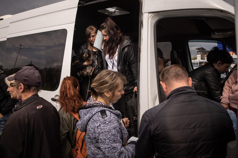 People disembark a van to be registered by police after arriving in Zaporizhzhia. Getty Images