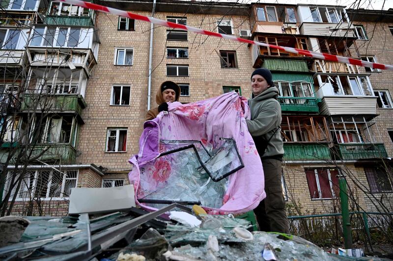 Residents remove debris after the explosion of a downed Russian drone. AFP