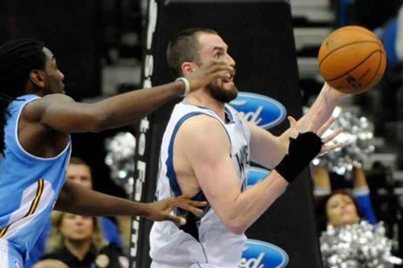 Minnesota's Kevin Love shields the ball from Denver's Kenneth Faried in his first game back from injury