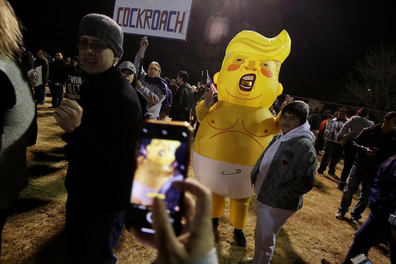 A man wearing an inflatable suit representing Donald Trump poses for a photo during the 'March for Truth: Stop the Wall, Stop the Lies'. Reuters