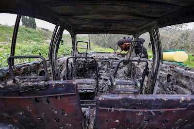 A Palestinian man inspects a car burnt in a reported attack by Israeli settlers in the village of Burqa, north-west of Nablus, the West Bank. AFP