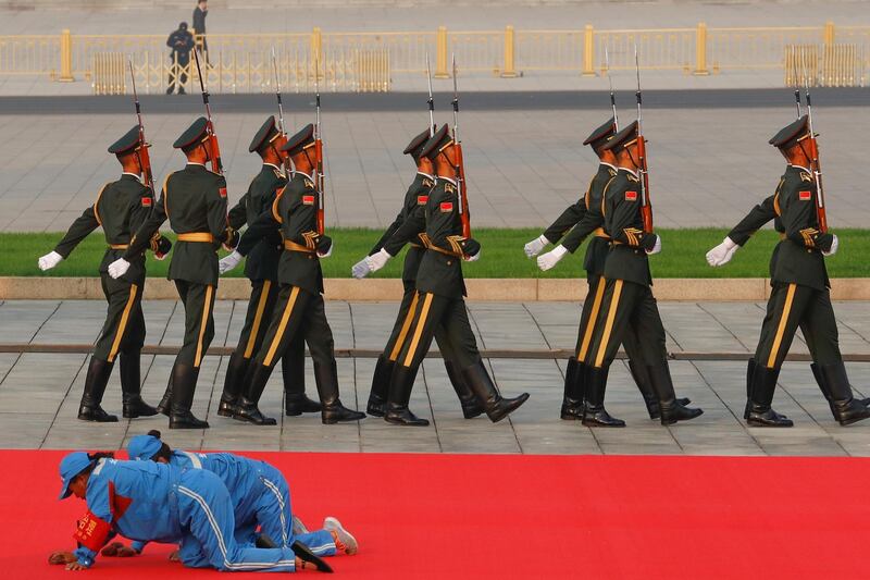 Workers clean a red carpet before a wreath laying ceremony at the Monument to the People's Heroes in Tiananmen Square, in Beijing, China. Reuters