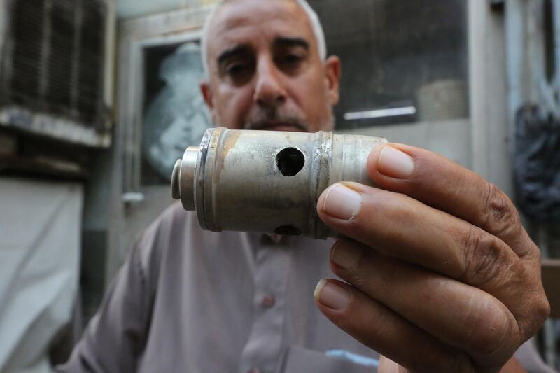 An Iraqi man shows an empty tear gas canister in the capital Baghdad's Tahrir square.  AFP
