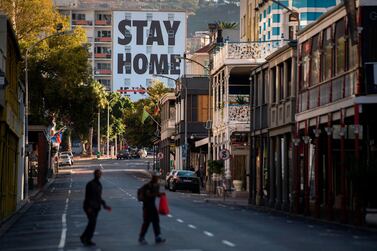 Two men walk across Long Street, usually one of the busiest and most popular entertainment areas in Cape Town, with a billboard reading Stay Home. South Africa came under a nationwide lockdown on March 27, 2020, joining other African countries imposing strict curfews and shutdowns in an attempt to halt the spread of Covid-19. Afp