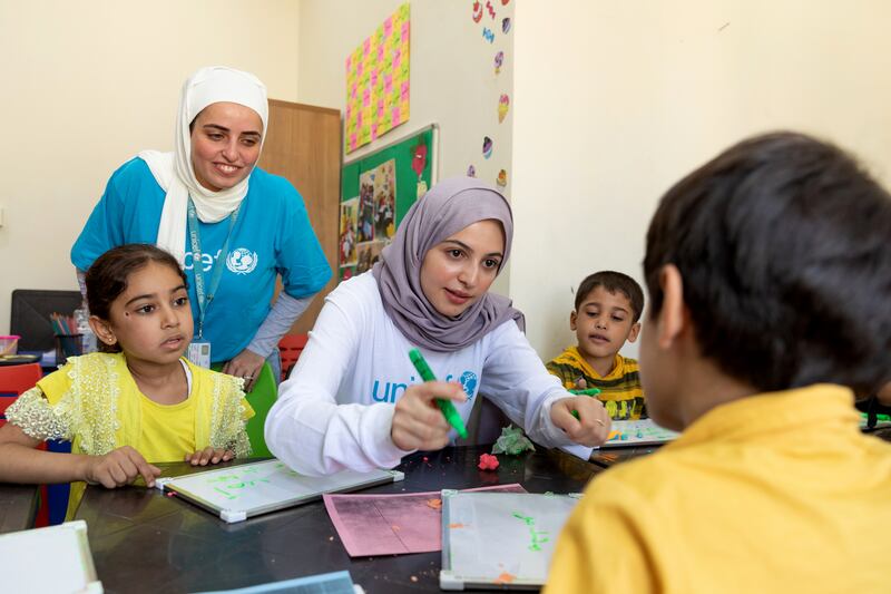 Muzoon Almellehan and Alaa Khaled Hasan with Ahla, 8, left, during an Arabic learning support class.

