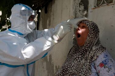 A woman reacts as a swab sample is taken from her nose for a coronavirus test in a suburb of the Jordanian capital Amman. AFP