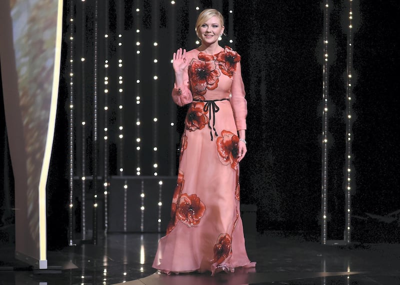 US actress and member of the Jury Kirsten Dunst waves as she arrives on stage on May 11, 2016 during the opening ceremony for the 69th Cannes Film Festival, southern France. (Photo by ALBERTO PIZZOLI / AFP)