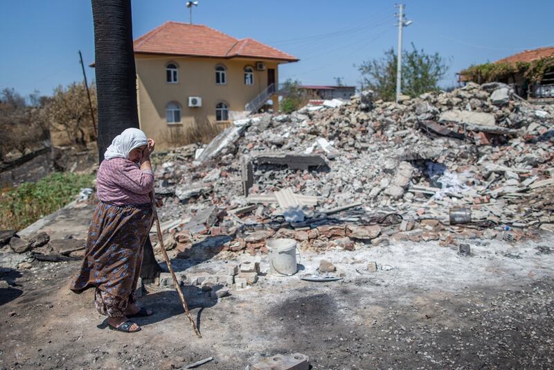 Cemile Gullu cries in front of the burnt remains of her house after a bushfire in Bucak village in the Manavgat district of Antalya, Turkey. EPA