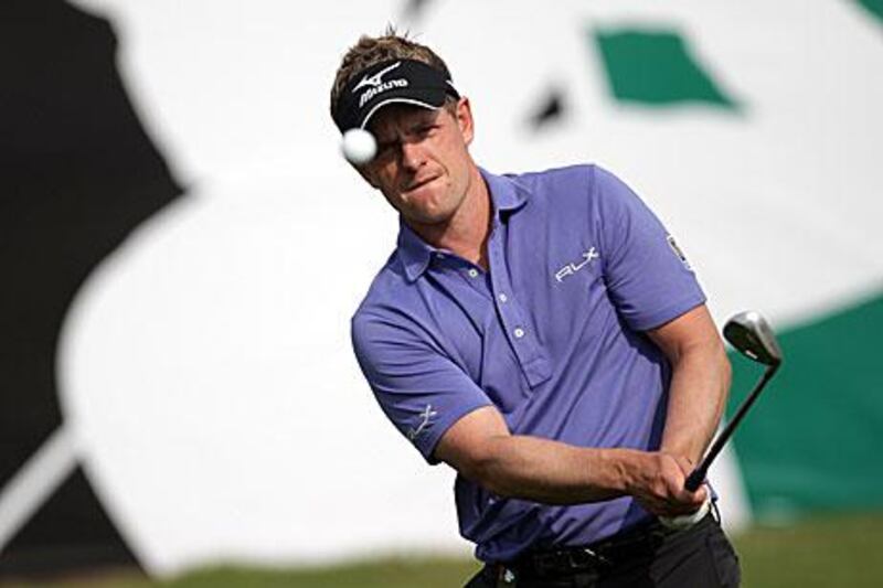 Luke Donald plays a shot from the rough around the 18th green during a practice round prior to the Dubai World Championships on the Earth Course.