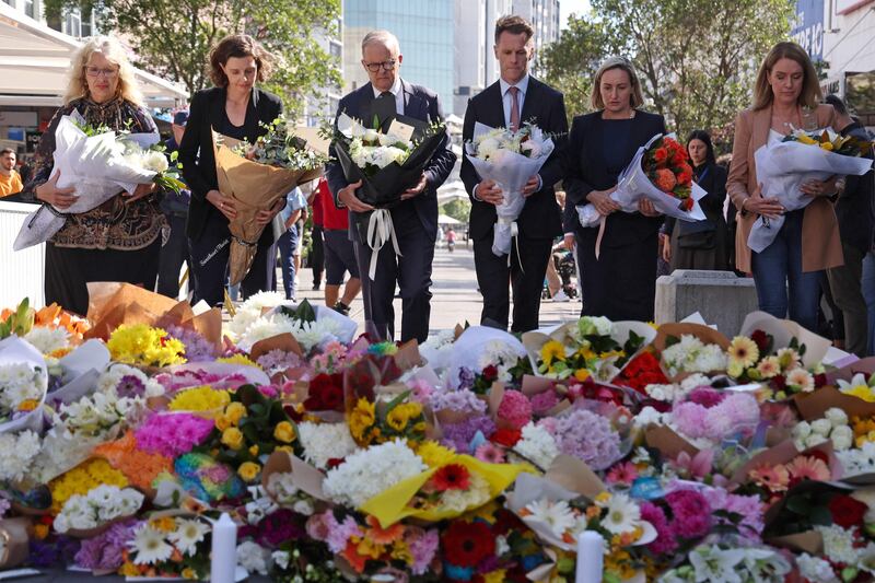 Australian Prime Minister Anthony Albanese stands with New South Wales Premier Chris Minns and other officials as they prepare to leave flowers outside the Westfield Bondi Junction shopping mall in Sydney. AFP