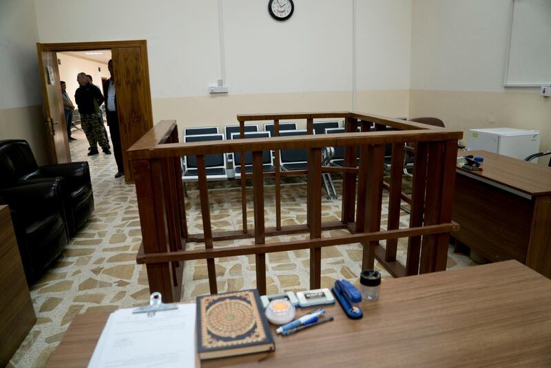 FILE - in this Thursday, April 26, 2018 file photo, the defendant's cage is in the center of an empty courtroom at Nineveh Criminal Court, one of two counterterrorism courts in Iraq where suspected Islamic State militants and their associates are tried, in Tel Keif, Iraq. A Baghdad court sentenced to death three French citizens Sunday for being members of the Islamic State group, an Iraqi judicial official said. The official said the three were among 12 French citizens handed over to Iraq in January by the U.S.-backed Syrian Democratic Forces. Then SDF has handed over to Iraq hundreds of suspected IS members in recent months. (AP Photo/Maya Alleruzzo, File)
