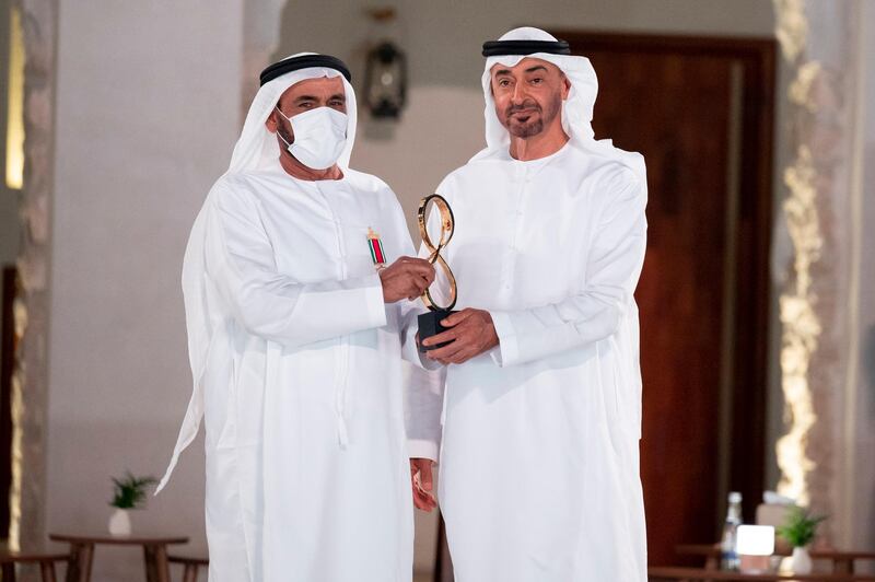 ABU DHABI, UNITED ARAB EMIRATES - April 07, 2021: HH Sheikh Mohamed bin Zayed Al Nahyan, Crown Prince of Abu Dhabi and Deputy Supreme Commander of the UAE Armed Forces (R), presents an Abu Dhabi Award to Lieutenant General (Rtd.) Obaid Mohammed Al Kaabi (L), during an awards ceremony, at Qasr Al Hosn.

( Mohamed Al Hammadi / Ministry of Presidential Affairs )
---