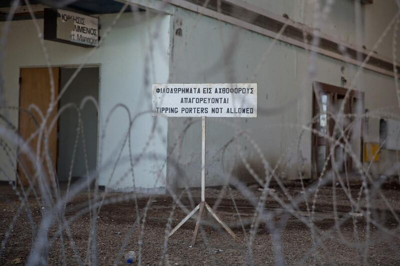 A sign is seen through barbed wire at the airport.