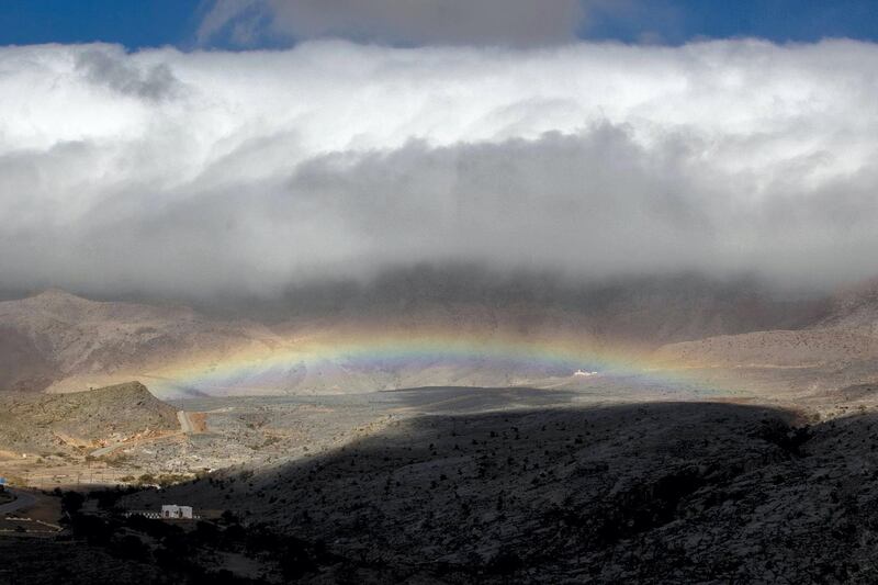 Clouds and a rainbow en route to the viewpoint of Jebel Shams, Oman. Charlotte Mayhew / The National
