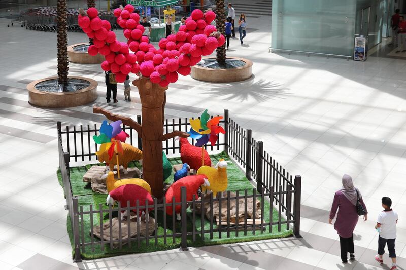 People walk past a colorful muttons paddock installation, at a mall in Amman, Jordan. EPA