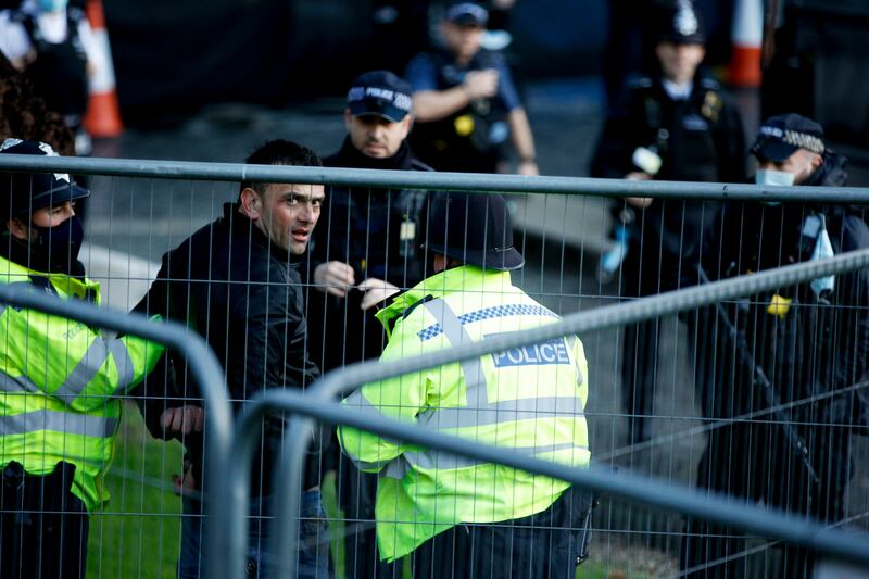 Police officers arrest a man who entered the grounds of the Houses of Parliament in London. AP