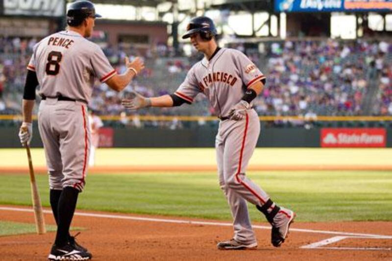 San Francisco Giants' Buster Posey is congratulated by teammate Hunter Pence after hitting a two-run homer against Colorado Rockies in Denver.