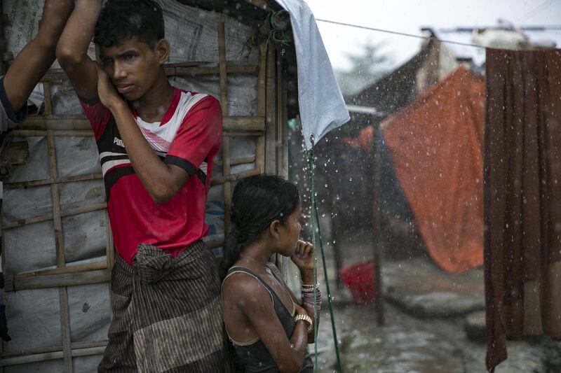 Rohingya are taking shelter during a rainstorm at the Nayapara refugee camp. Getty Images