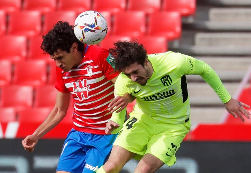 Granada's Jesus Vallejo and Sime Vrsaljko of Atletico challenge for a header. Reuters