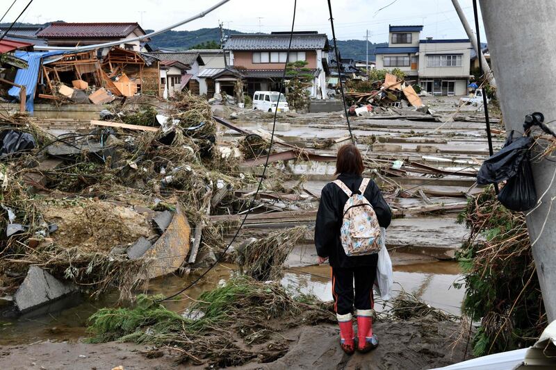 A woman looks at flood-damaged homes in Nagano, after Typhoon Hagibis hit Japan on October 12 unleashing high winds, torrential rain and triggered landslides and catastrophic flooding. Rescuers in Japan worked into a third day in an increasingly desperate search for survivors of a powerful typhoon that killed nearly 70 people and caused widespread destruction. AFP