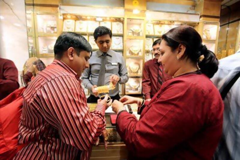 Indian tourists Vikram Mehta and his wife Priti buy jewellery, right, at a jewellery shop in the Gold Souk in Deira, Dubai. Pawan Singh / The National