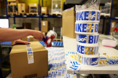 A worker seals a shipping box with adhesive tape at the Bike24 Holding AG logistics center in Dresden, Germany, on Tuesday, June 8, 2021. Bike24 is preparing to list on the Frankfurt Stock Exchange. Photographer: Liesa Johannssen-Koppitz/Bloomberg