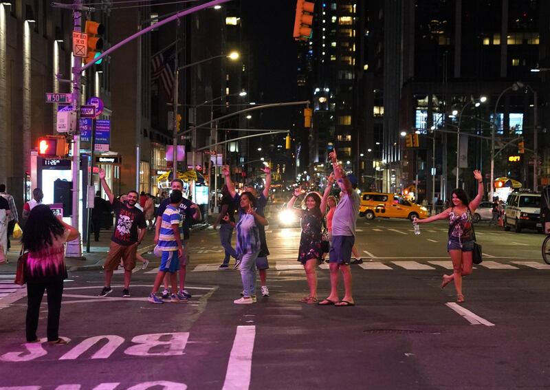 People celebrate on 6th Ave after the lights came back on.  AFP