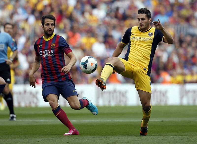 Barcelona midfielder Andres Iniesta, left, and Atletico player Koke challenge for the ball during their contest on Saturday. Emilio Morenatti / AP / May 17, 2014