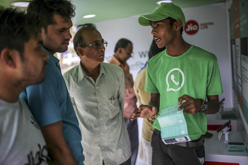 A WhatsApp ambassador speaks with customers on board an open truck during a roadshow for Facebook Inc.'s WhatsApp messaging service and Reliance Jio Infocomm Ltd.'s wireless network in Pune, India, on Thursday, Oct. 25, 2018. Facebook and Reliance Jio are teaming up to draw hordes of customers with cheap phones, rock-bottom rates and handy messaging services. Photographer: Dhiraj Singh/Bloomberg