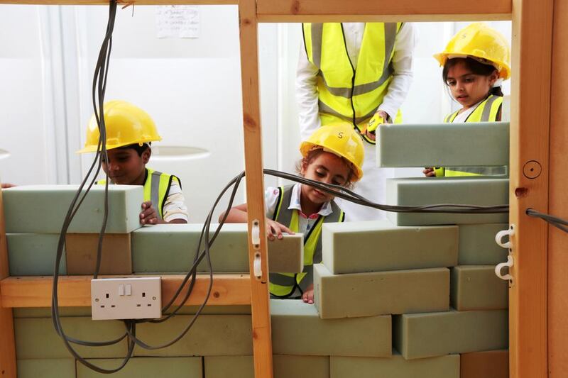 Children construct a wall while taking part in a 'build it' activity. Christopher Pike / The National