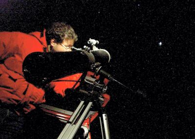 A Chilean astronomer observes the planet Mars through a telescope in the outskirts of Santiago, late 26 August, 2003. Mars is getting ready for its close-up, with the red planet coming as near to Earth this month as it has in almost 60,000 years. AFP PHOTO/ Victor ROJAS / AFP PHOTO / VICTOR ROJAS