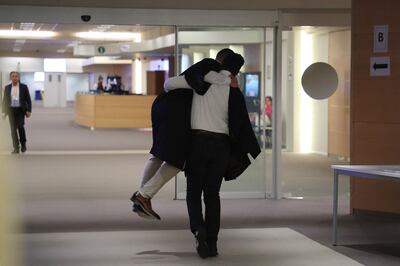Ibrahim Farisi embraces his lawyer after being found not guilty of all charges in Brussels. AFP