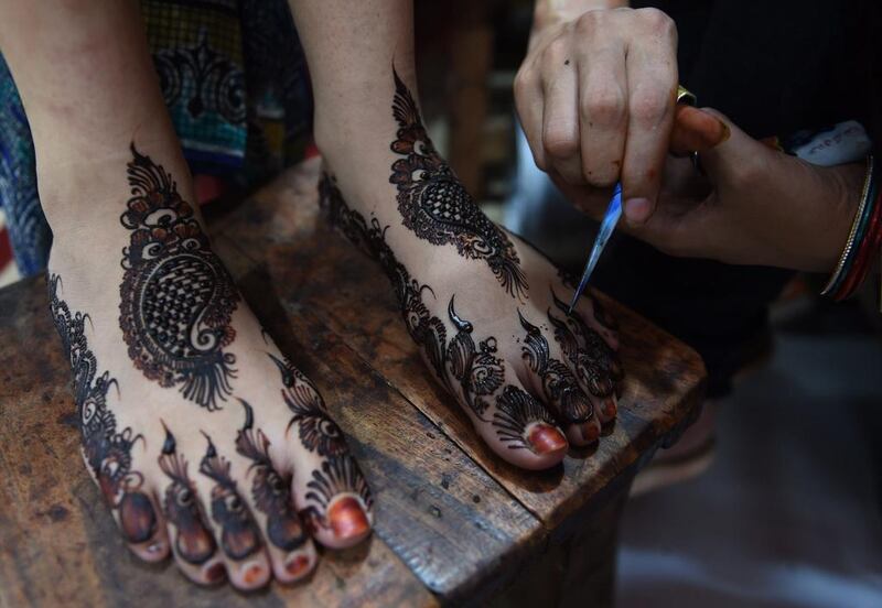A Pakistani beautician applies henna designs to a customer ahead of the Eid Al Fitr holiday which marks the end of Ramadan at a beauty salon in Karachi. Muslims globally have been marking the month of Ramadan which ends with the Eid Al Fitr holiday. Asif Hassan / AFP photo