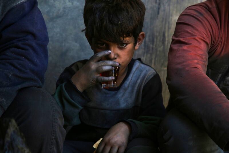 A boy sips a cup of tea during a break at a factory in Al Bab, on the outskirts of Aleppo. Thousands of vulnerable children in Syria are being forced to take up work due to the devastating effects of a civil war that began in 2011. AFP