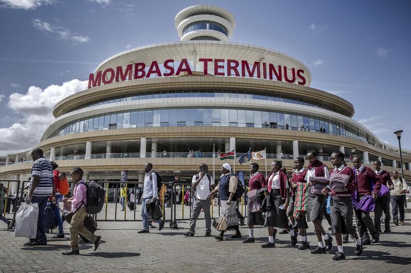 Rail travelers pass the entrance to Mombasa SGR Terminus station in Mombasa, Kenya, on Saturday, Sept. 1, 2018. China's modern-day adaptation of the Silk Road, known as the Belt and Road Initiative, aims to revive and extend trading routes connecting China with Central Asia, the Middle East, Africa and Europe via networks of upgraded or new railways, ports, pipelines, power grids and highways. Photographer: Luis Tato/Bloomberg