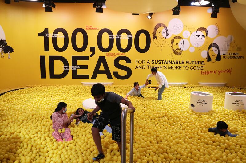 Visitors inside the yellow ball pit at the Germany pavilion.