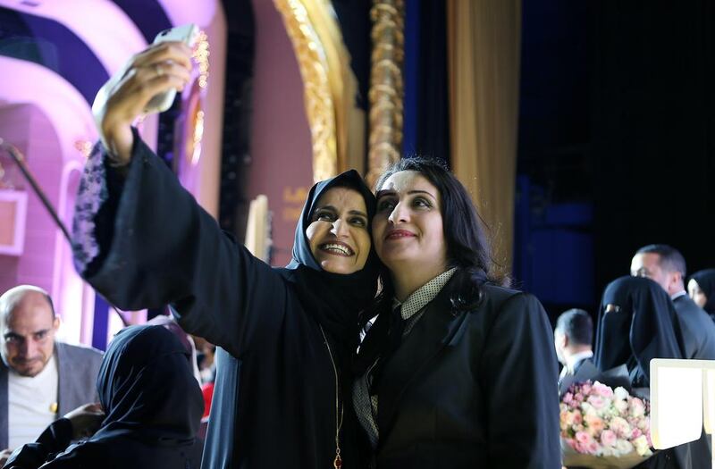 One of the guests takes a selfie with the winner of the Khalifa Award for Education, Ghania Aref Al Banna, right, from Applied Technology High School, Abu Dhabi. The award ceremony held at Emirates Palace Theatre in Abu Dhabi.  Pawan Singh / The National